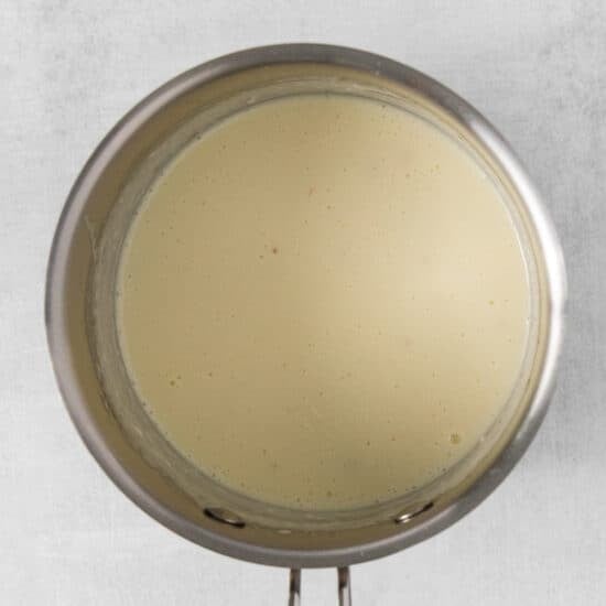 a pan with a white liquid on a white background.