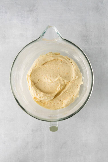 a glass bowl filled with a yellow batter.