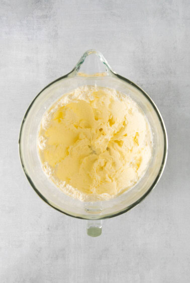 butter in a glass bowl on a gray background.
