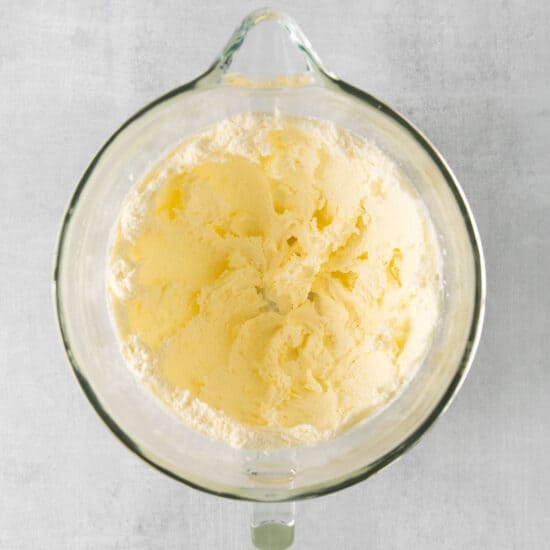 butter in a glass bowl on a gray background.
