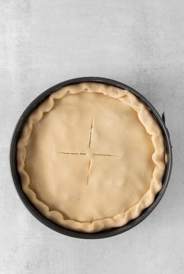 a pie crust in a pan on a grey background.