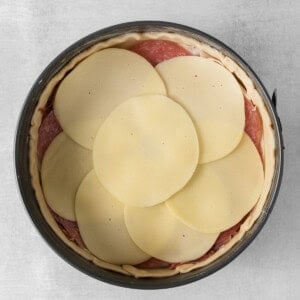 a pie with slices of cheese in a pan.