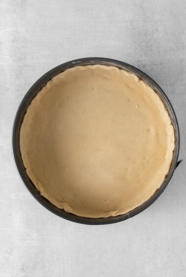 a pie crust in a pan on a white background.