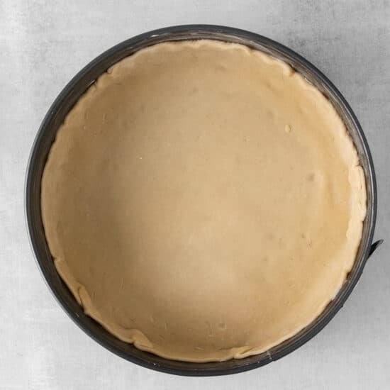 a pie crust in a pan on a white background.