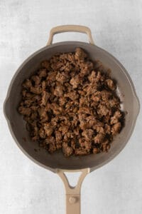 a frying pan filled with ground beef.