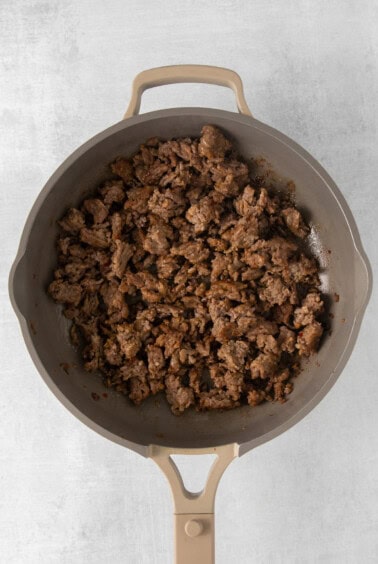a frying pan filled with ground beef.