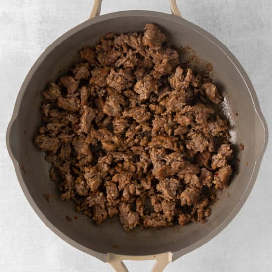 a frying pan filled with ground beef.