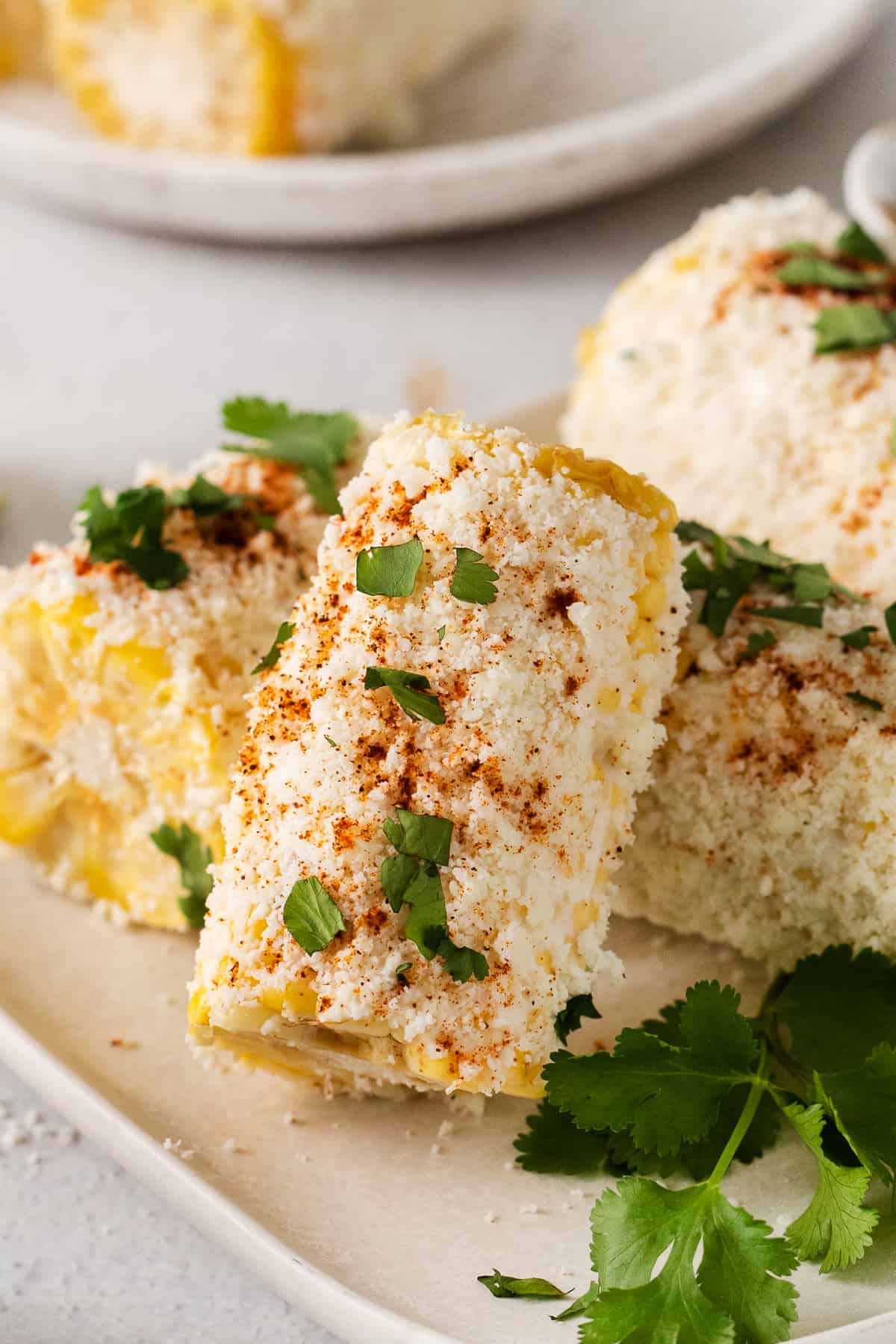 Elote corn on a plate topped with cilantro.