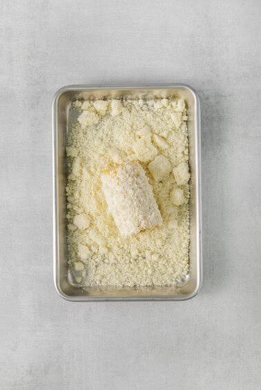 a tray filled with shredded cheese on a grey background.