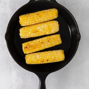 grilled corn on the cob in a cast iron skillet.