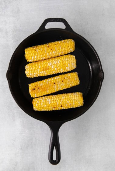 grilled corn on the cob in a cast iron skillet.