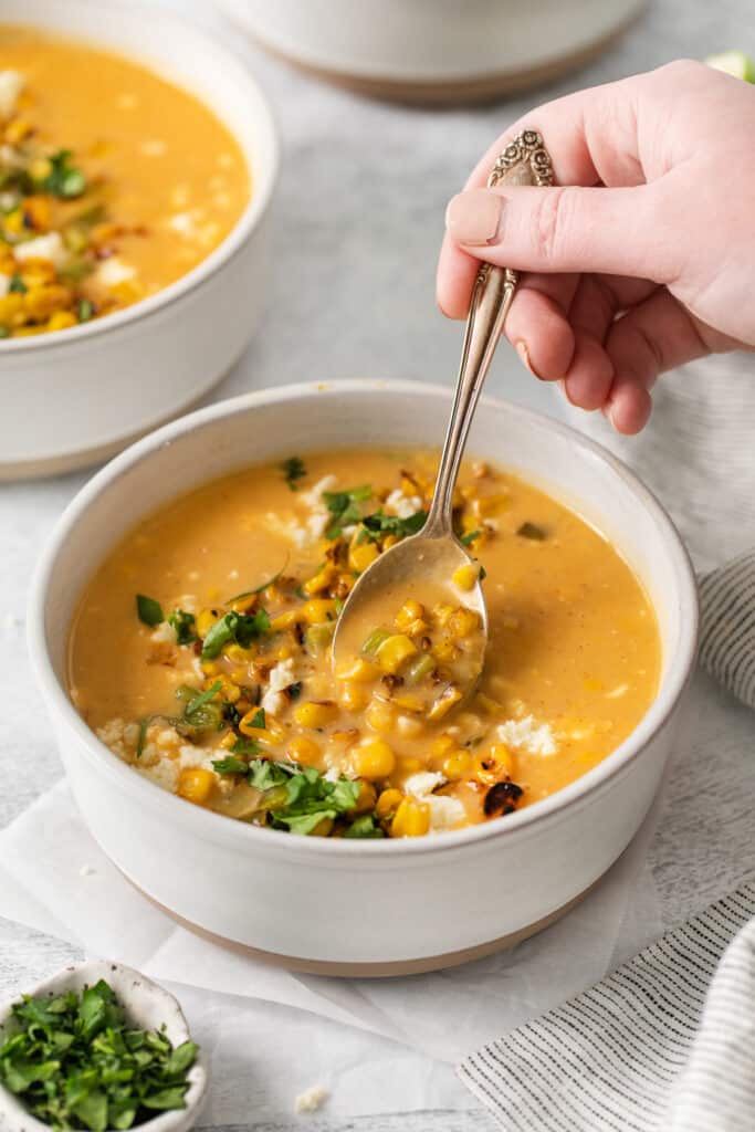 Mexican street corn soup in a bowl with a spoon.