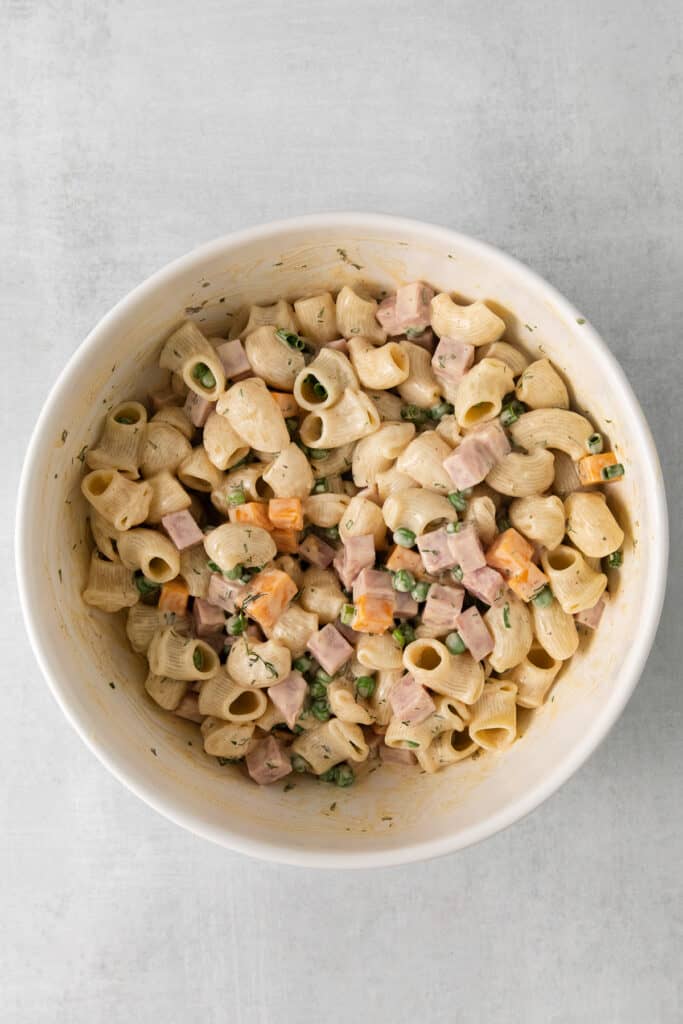 Ham and pea pasta salad mixed together in a bowl.