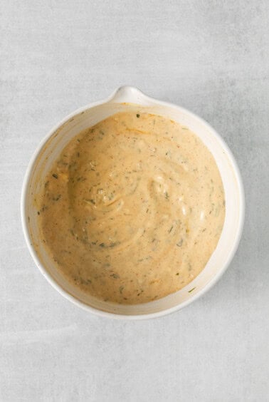 a white bowl with a sauce on it.