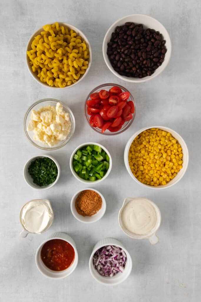 Mexican pasta salad ingredients in bowls.