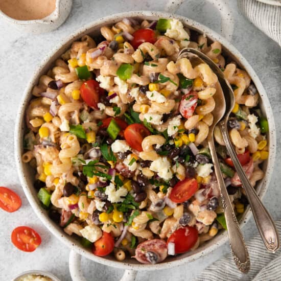 a bowl of pasta salad with black beans, tomatoes and corn.