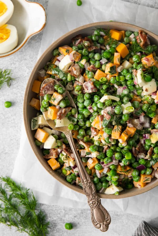 English pea salad in a bowl with a spoon.