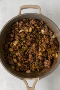 a skillet filled with ground beef and onions.
