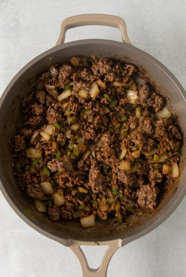 a skillet filled with ground beef and onions.