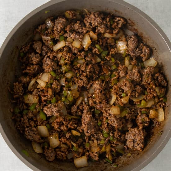 a skillet filled with ground beef and onions.
