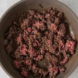 ground beef in a skillet on a white surface.