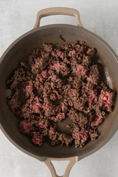 ground beef in a skillet on a white surface.