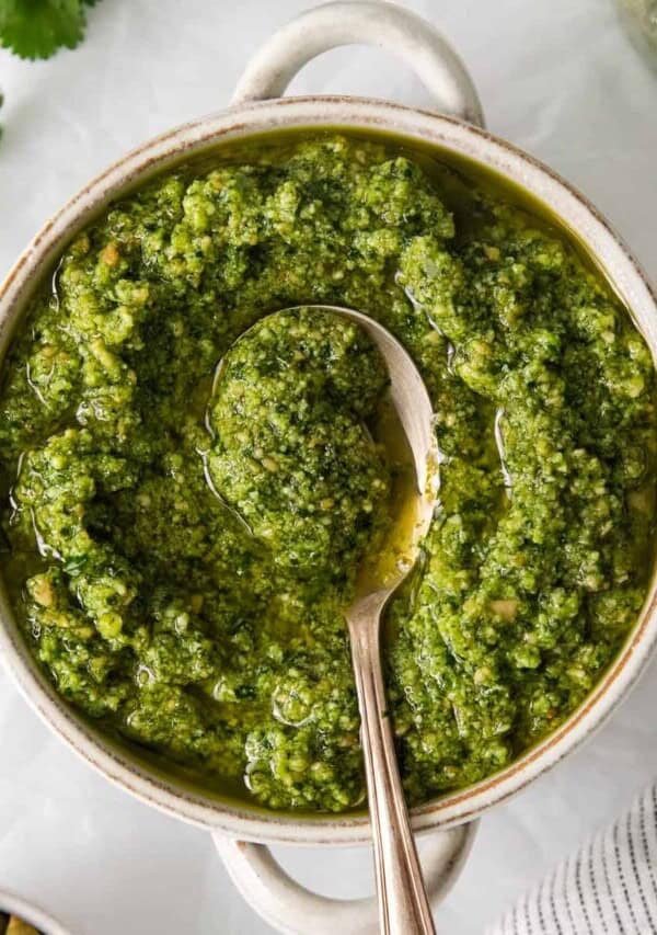 Cilantro pesto in a bowl with a spoon.