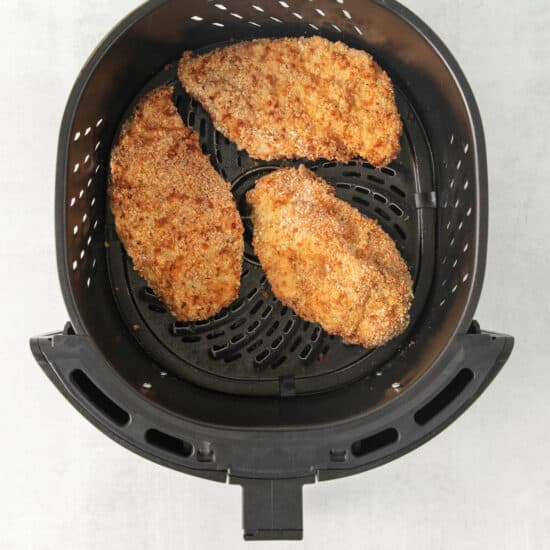 two chicken breasts in an air fryer.
