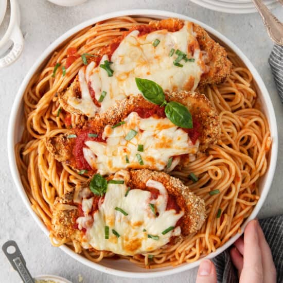 a bowl of spaghetti with chicken parmigiana.