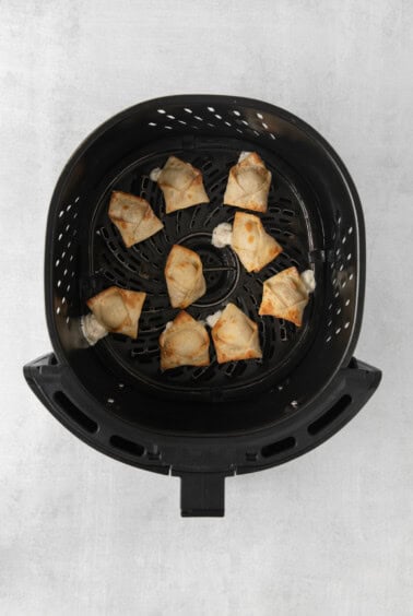 a black grill basket with fried dumplings in it.