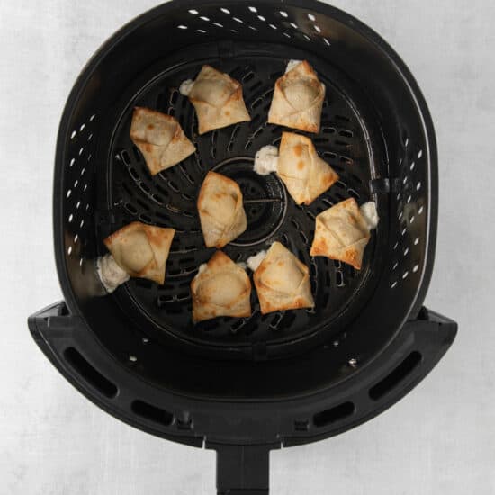a black grill basket with fried dumplings in it.
