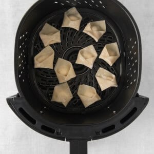 an air fryer filled with fried dumplings.