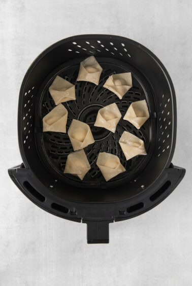 an air fryer filled with fried dumplings.