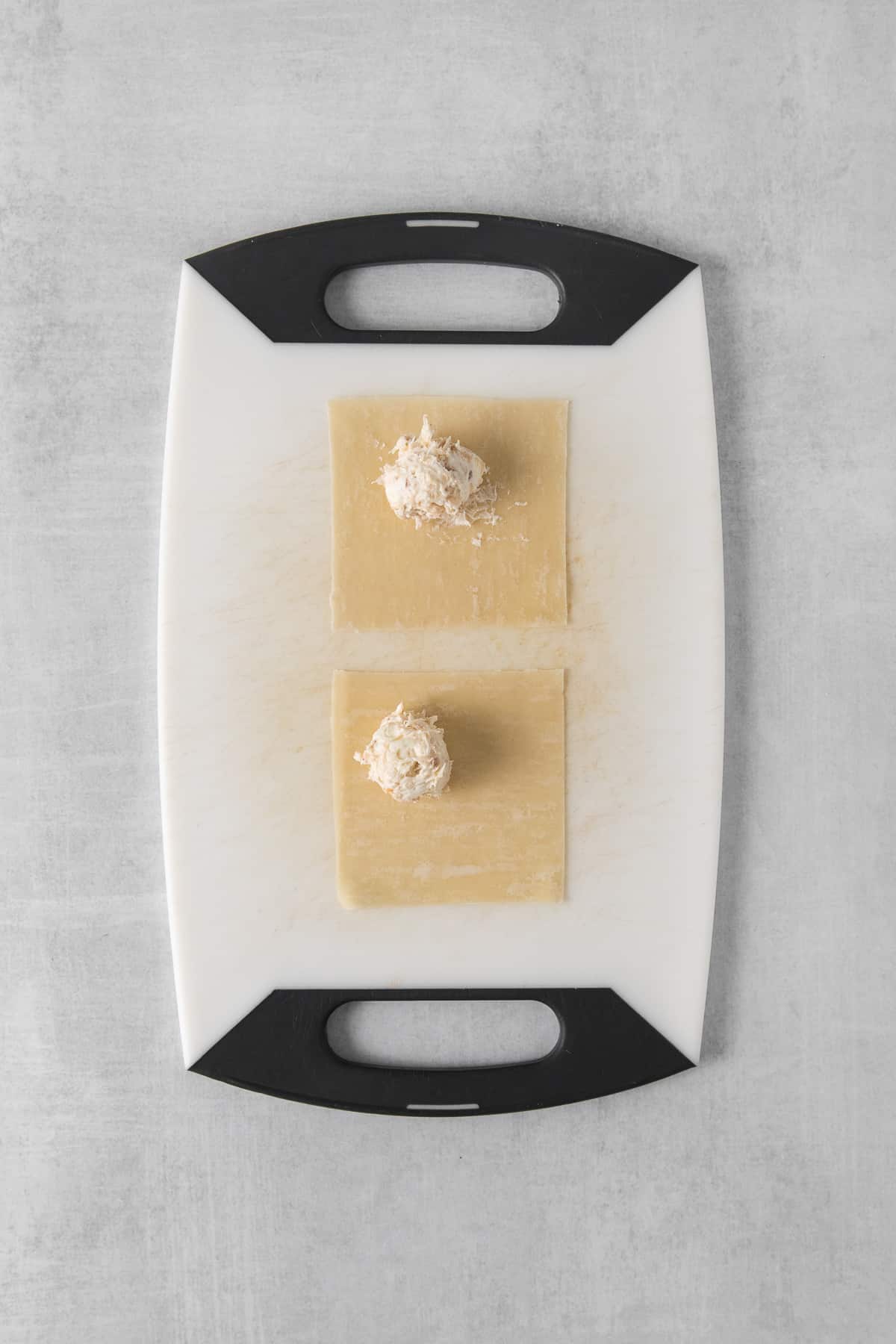 a cutting board with two pieces of pasta on it.