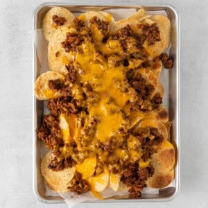 cheesy nachos in a tray on a white background.