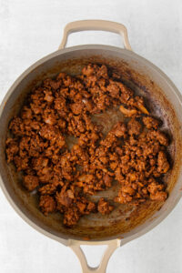 a pan with meat in it on a white surface.