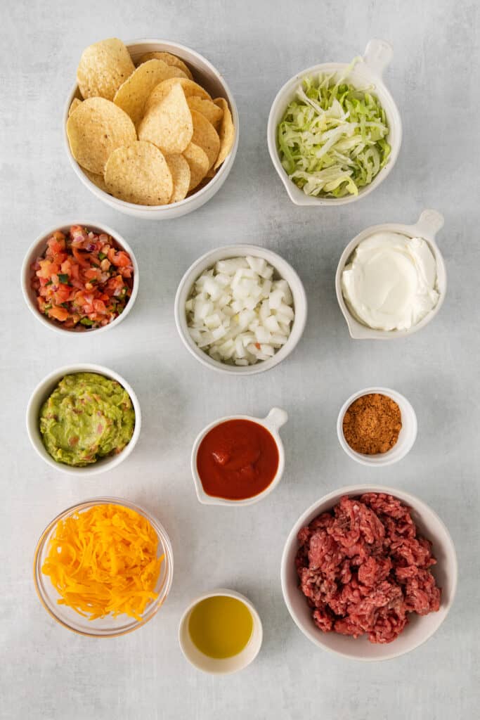 Ingredients for beef nachos in bowls.