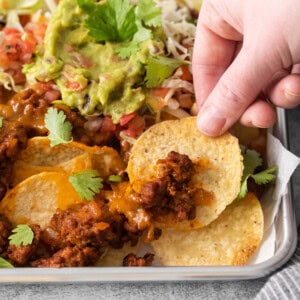 Ground beef nachos on a baking sheet.