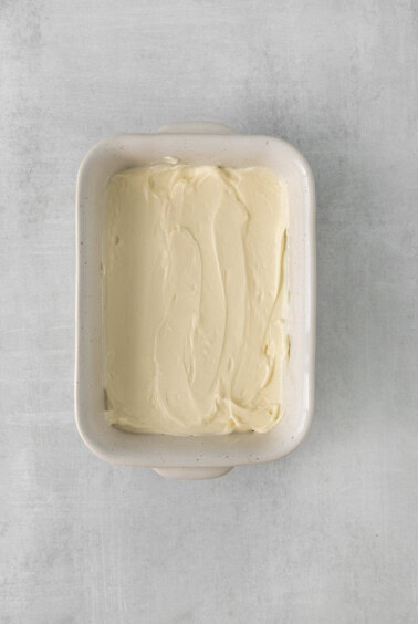 whipped cream in a square dish on a gray background.
