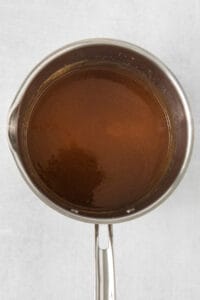 a pan full of brown liquid on a white surface.