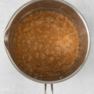 a pan filled with a brown liquid on a white surface.