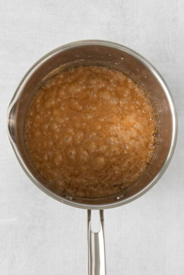 a pan filled with a brown liquid on a white surface.