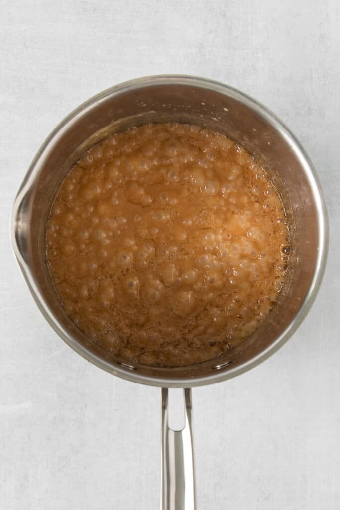 a pan filled with a brown liquid on a white surface.