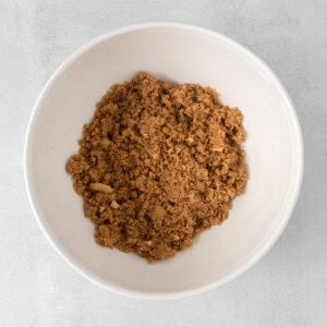 a white bowl filled with graham cracker on a white background.