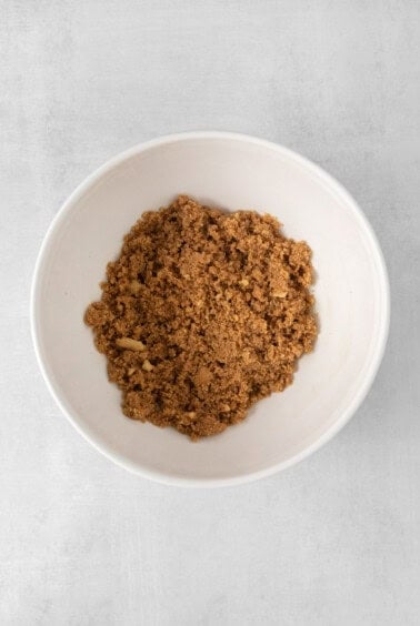 a white bowl filled with graham cracker on a white background.