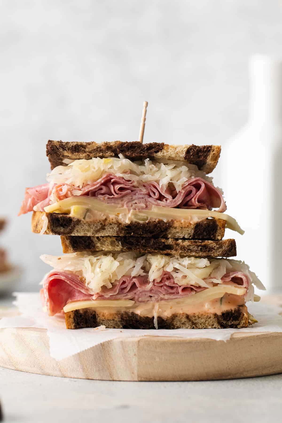 a ham and cheese sandwich on a wooden cutting board.