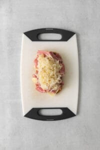 a cutting board with ham and cheese on it.