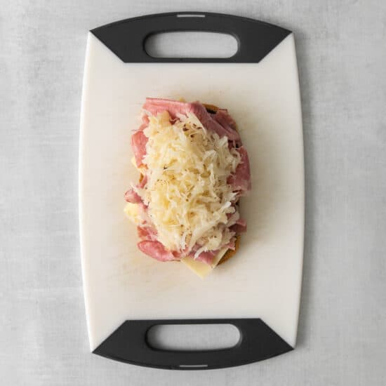 a cutting board with ham and cheese on it.