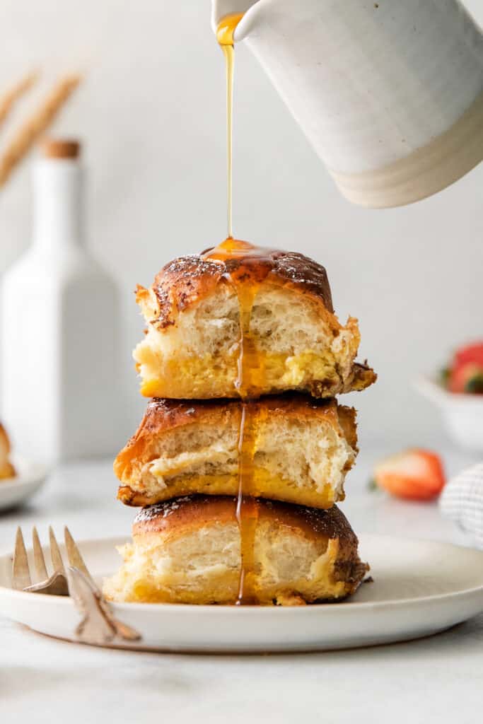 Hawaiian roll stuffed french toast stacked on a plate.