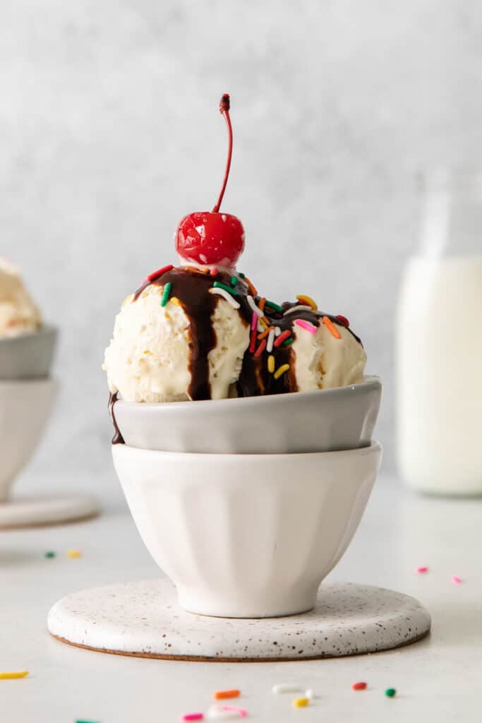 two bowls of ice cream with a cherry on top.
